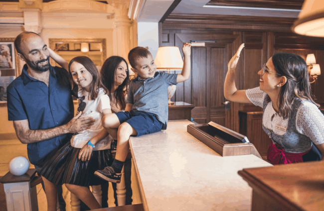 Famiglia con bambini alla reception dell'albergo per famiglie in Italia Cavallino Bianco.