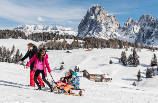 Famiglia con bambini sulle piste vicino al family hotel alto adige