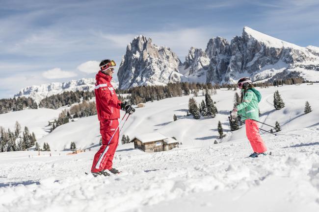 Child and ski instructor on ski slope.