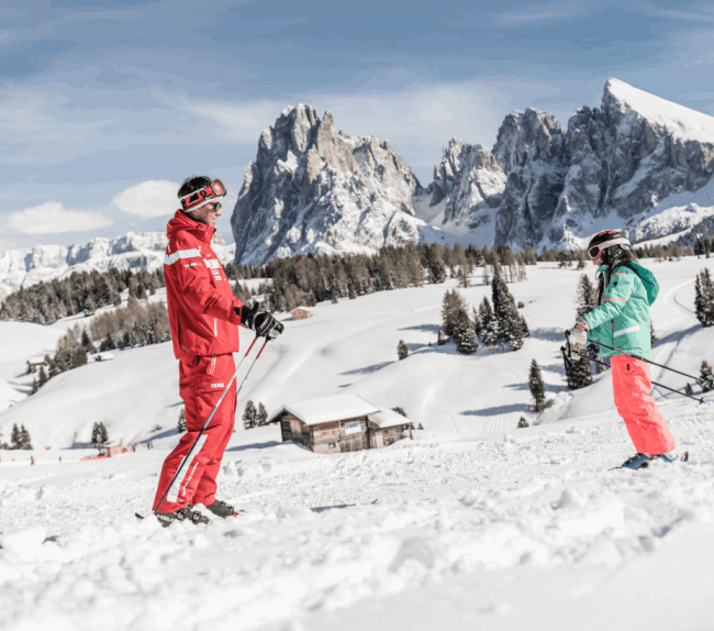 Child skiing with ski instructor outside the dolomiti ski hotel.