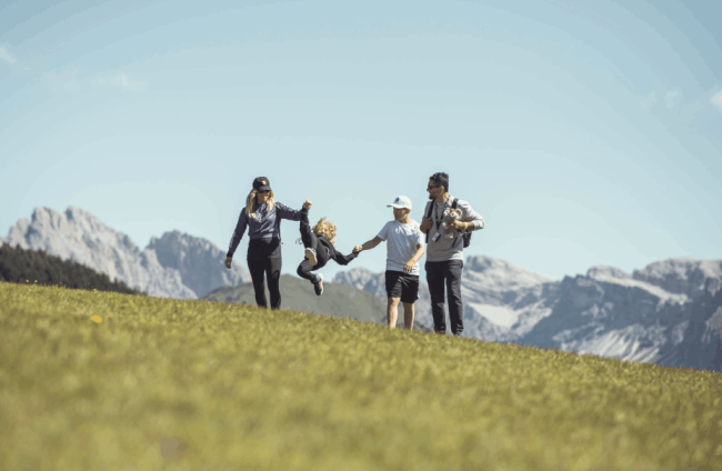 Famiglia con bambini sui prati delle Dolomiti - family resort italia.