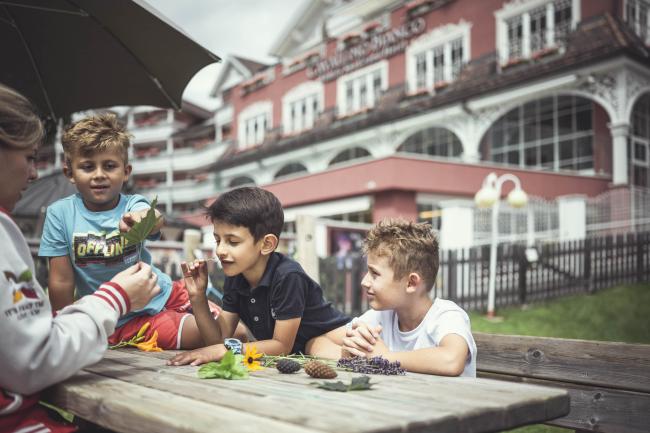 Bambini giocano sui tavoli del miglior hotel per bambini in alto adige