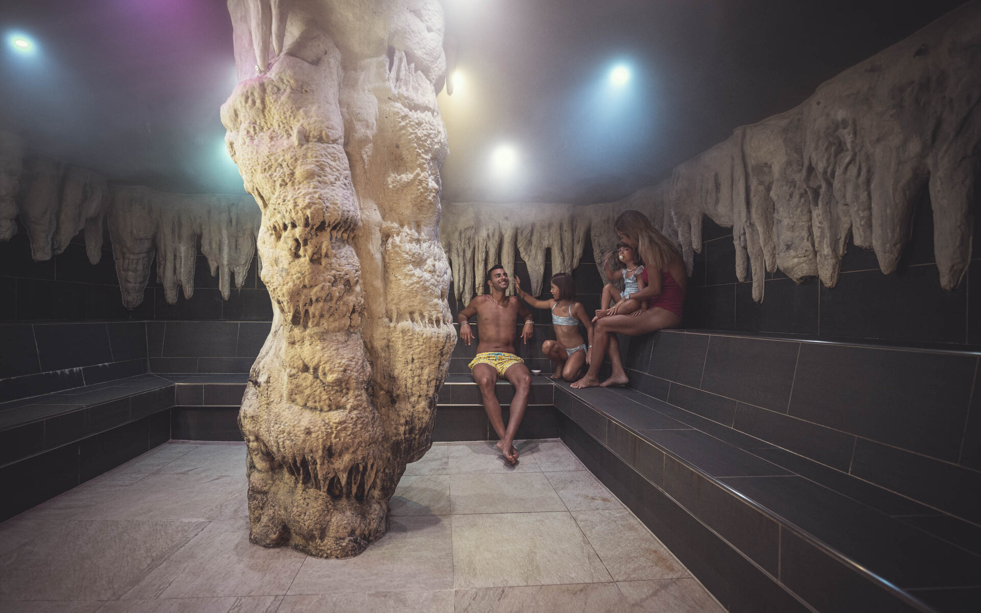 Mamma, papà e bambino nella sauna del family hotel vicino alle piste da sci sulle Dolomiti.