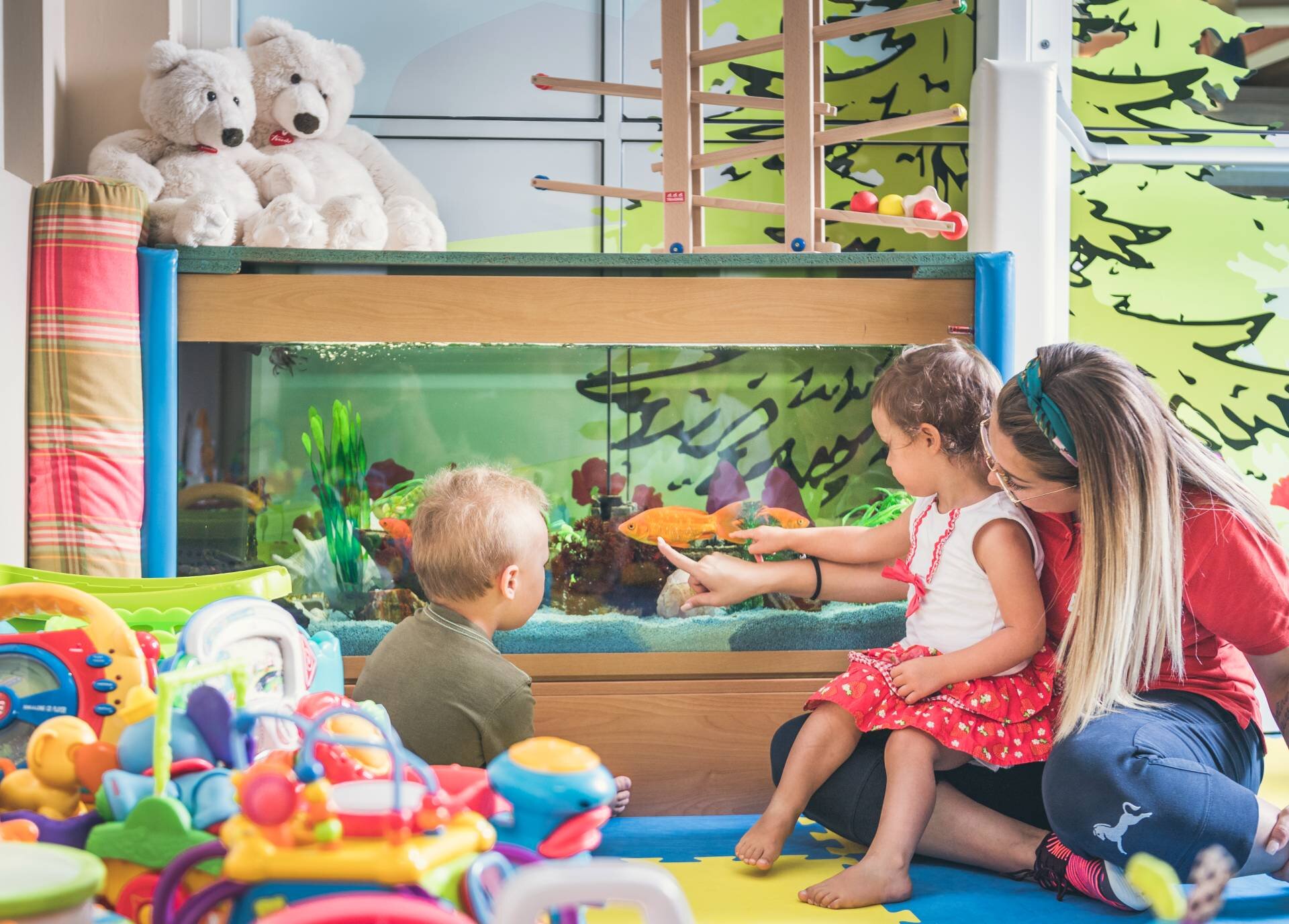 Bambini giocano con dada nell'hotel con baby club 0-3 anni.