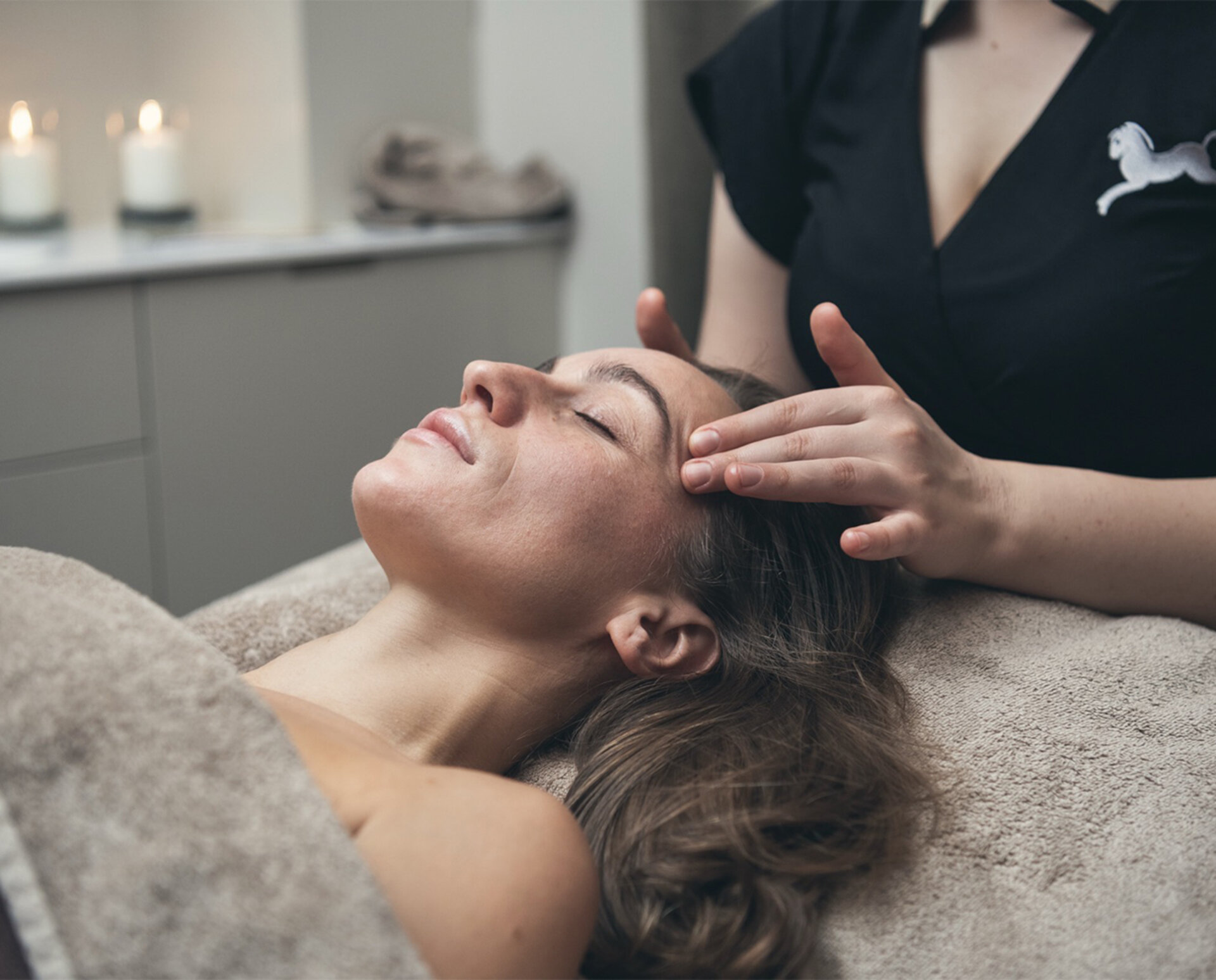 A woman lying down receives a forehead massage at the Cavallino Bianco spa hotel in Caorle.