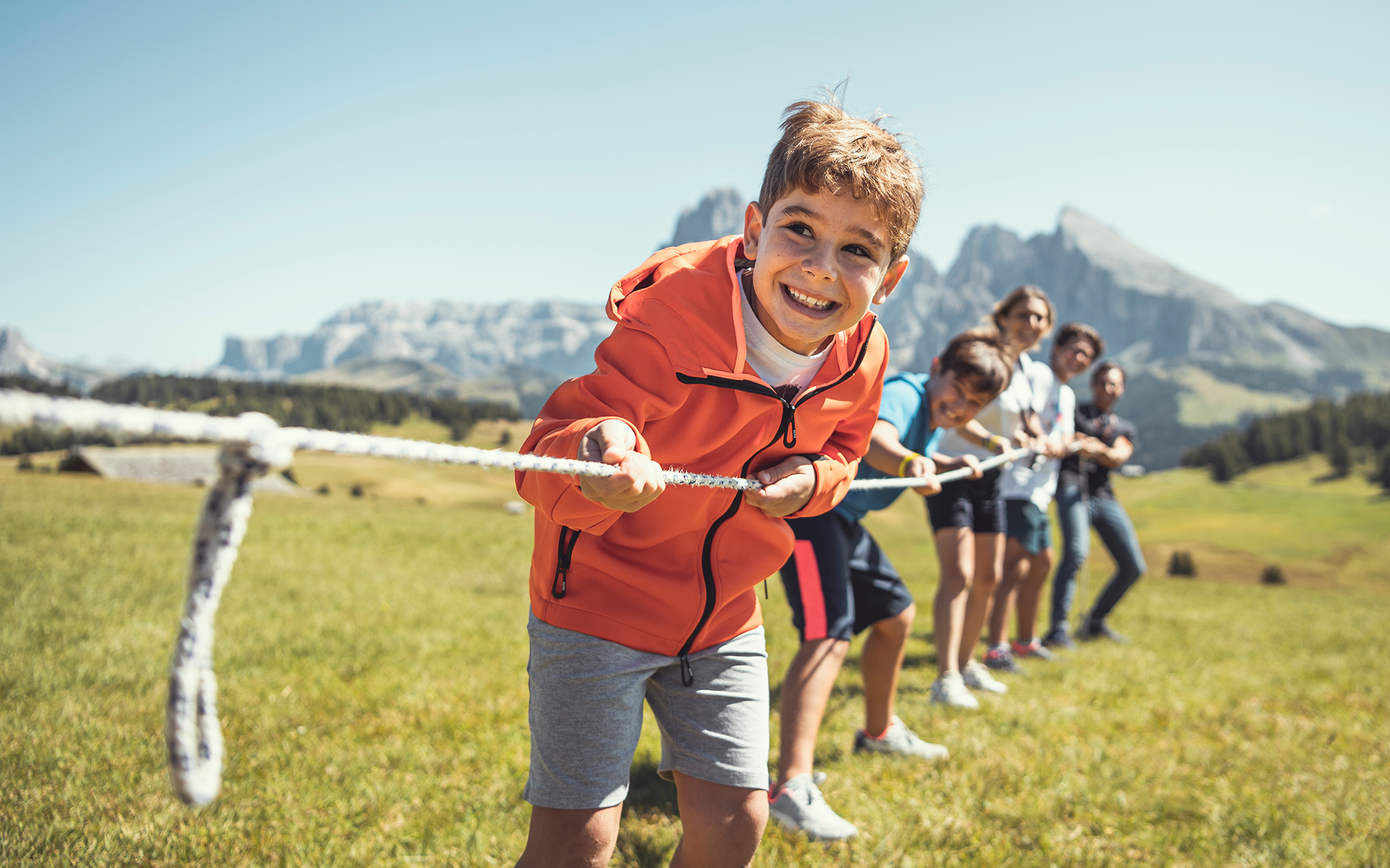 Bambini giocano al tiro alla corda fuori dal Cavallino Bianco Val Gardena - Dolomiti,  family hotel in Sud Tirolo - Alto Adige.