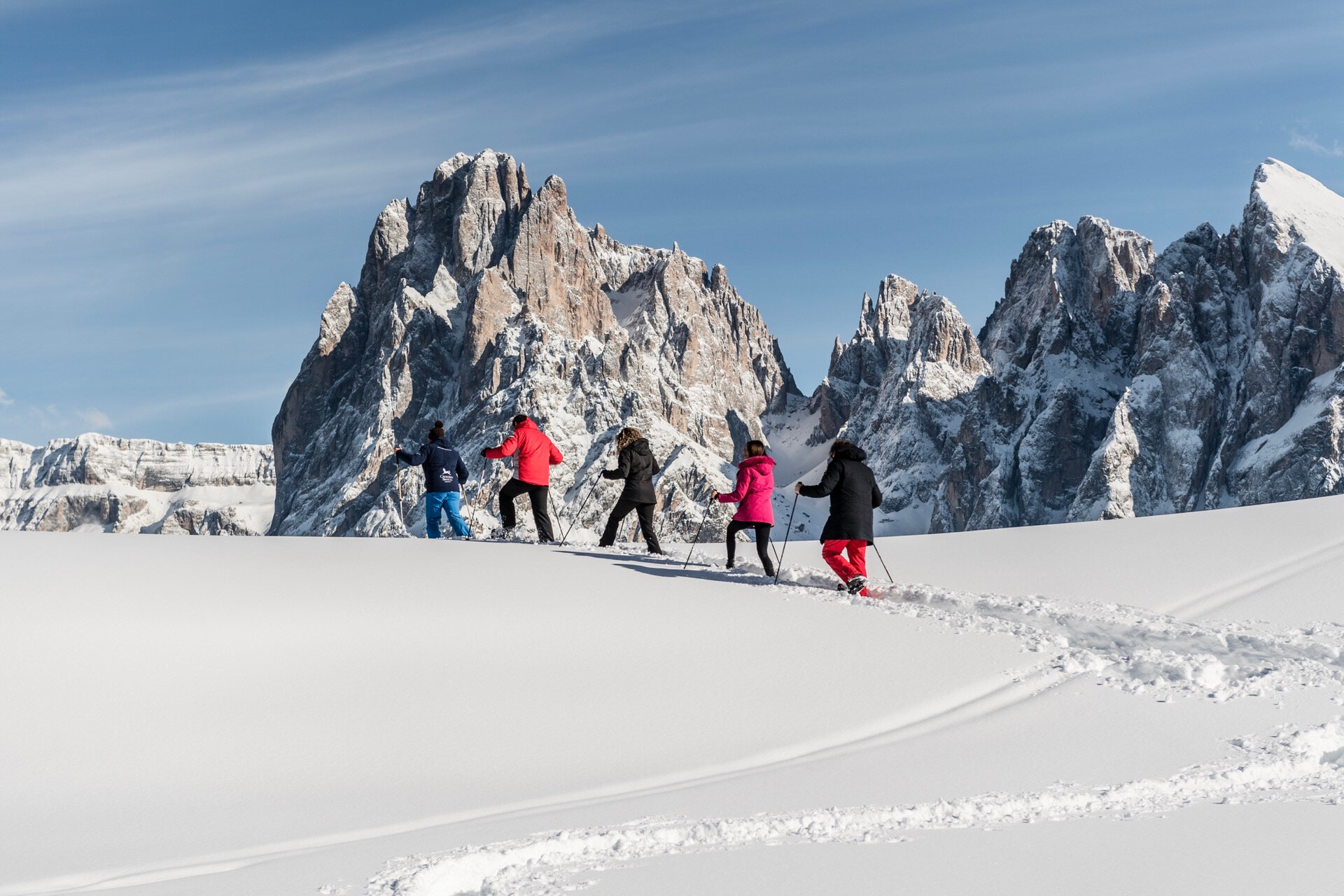 Famiglia in ciaspolata sui prati innevati del family hotel in alto adige.