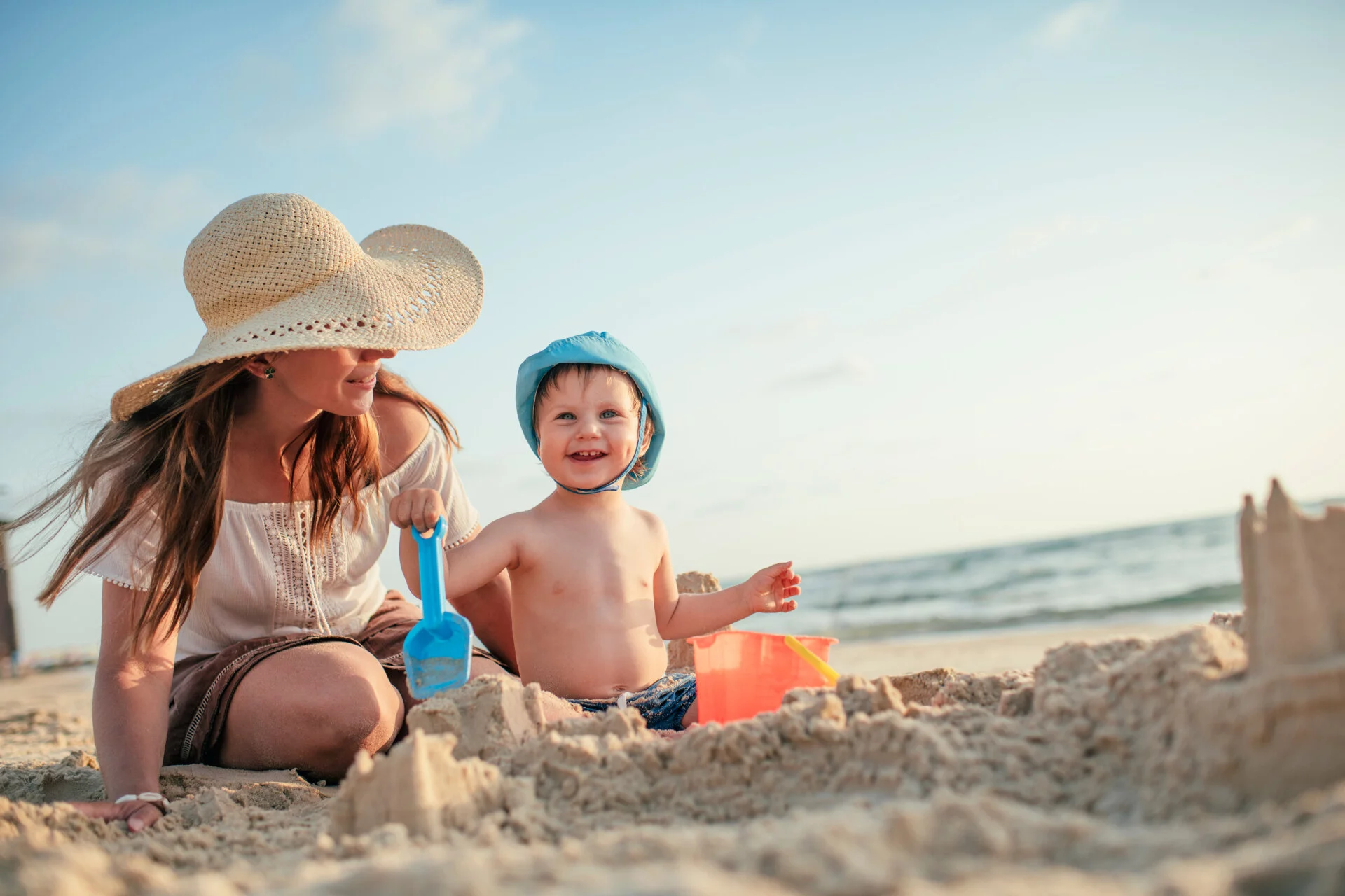 Bambino in spiaggia con animatrice del cavallino bianco, family hotel in italia.