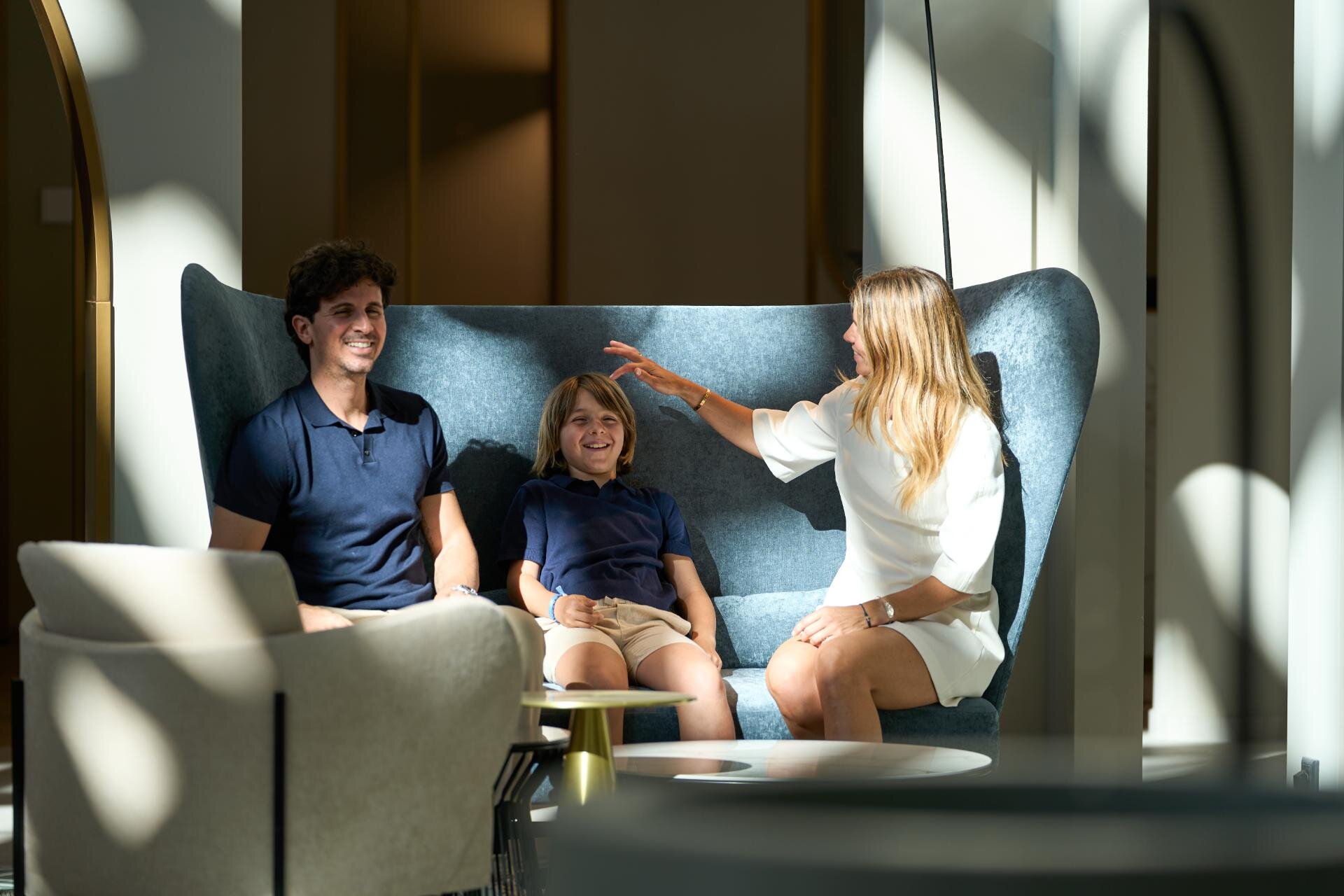 Famiglia sorridente seduta sui sofa del Cavallino Bianco a Caorle