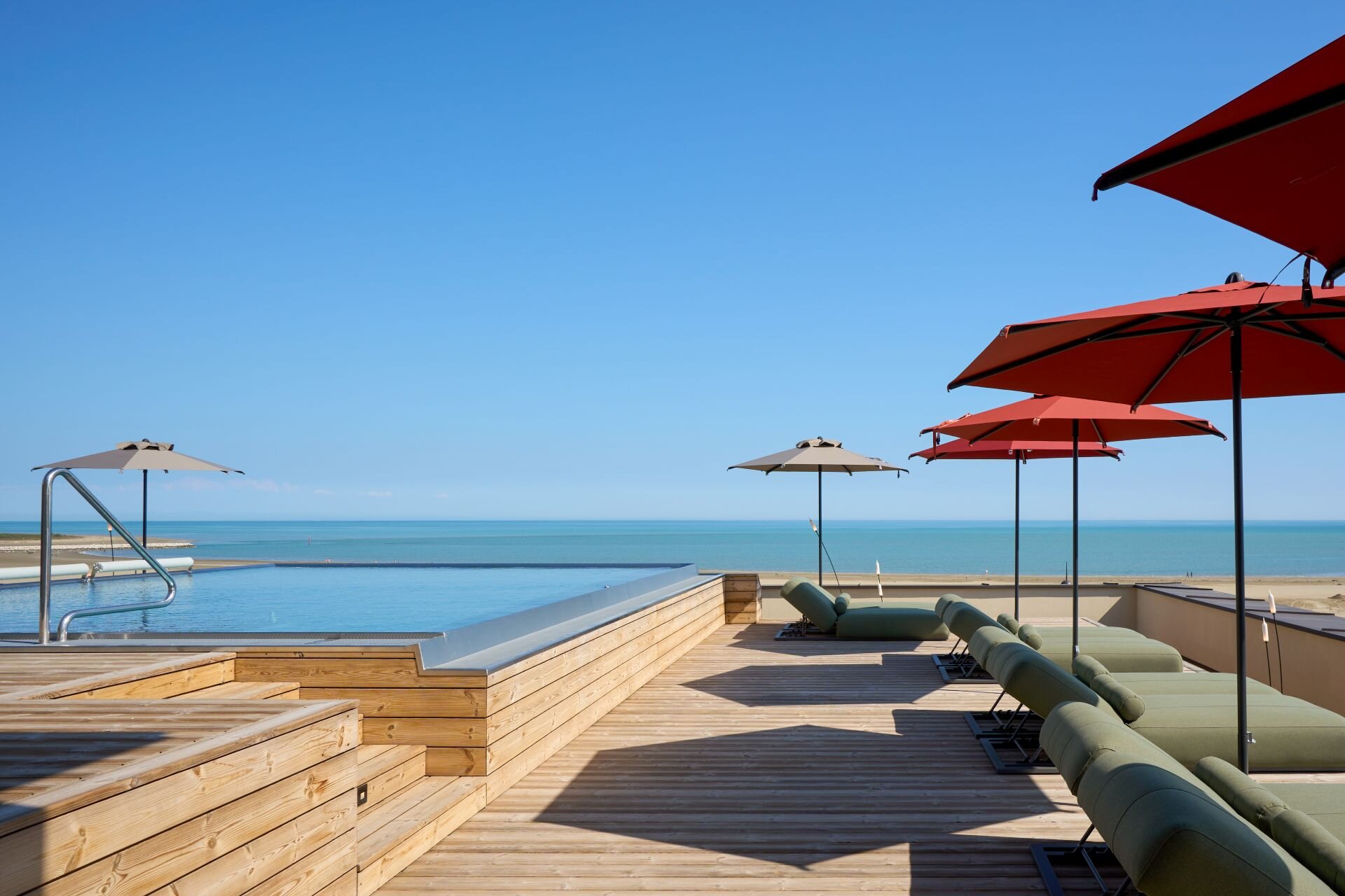 Adults-only panoramic infinity pool on the wooden rooftop overlooking the sea in Caorle.