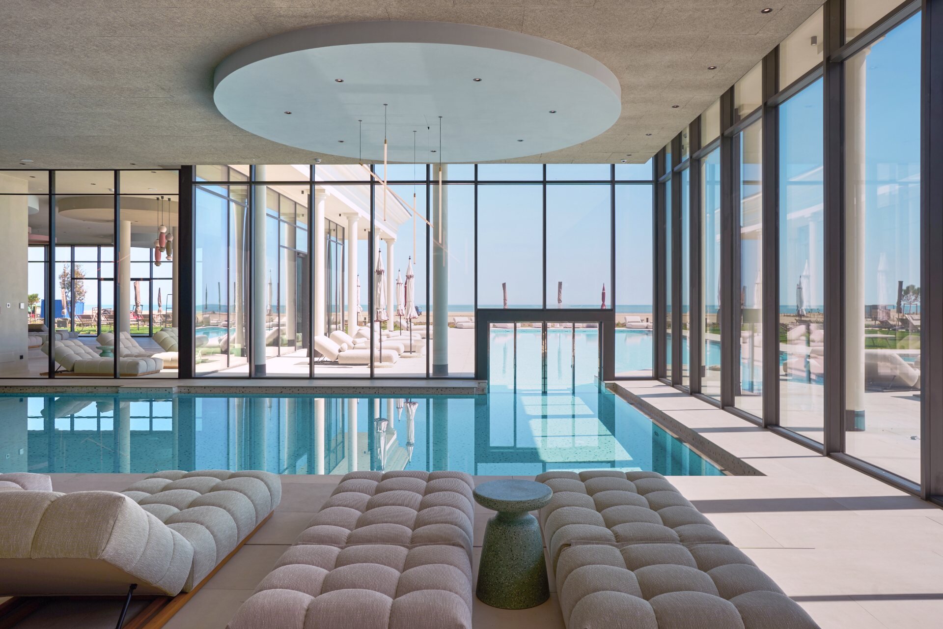 Relax on sun loungers by the heated indoor pool with large windows overlooking the sea at this family-friendly hotel in Caorle.