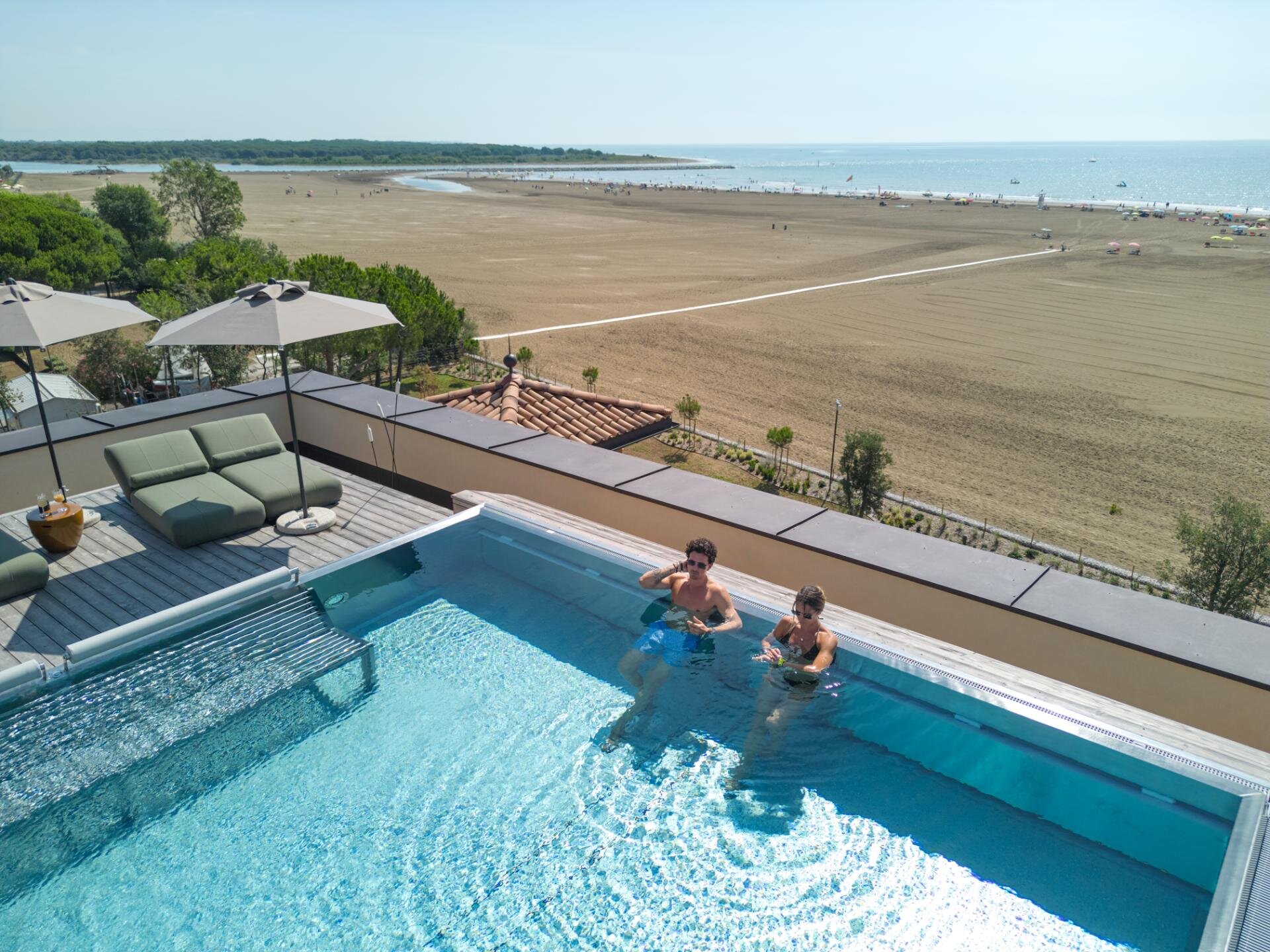 Piscina infinity sul rooftop in legno riservata agli adulti del resort a Caorle.