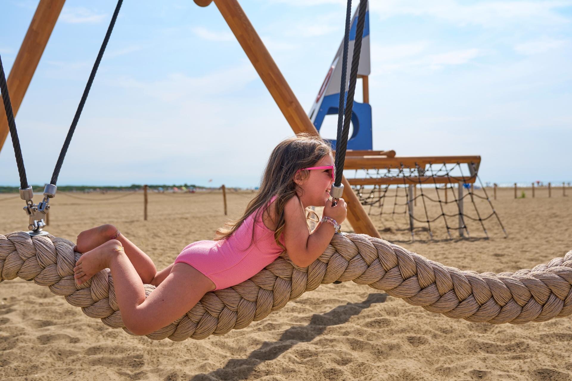 Bambina su giochi in mezzo alla spiaggia al Cavallino Bianco a Caorle